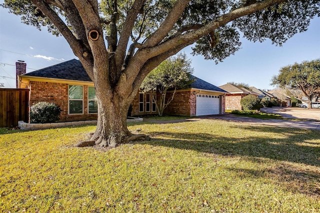 ranch-style home with a garage and a front lawn