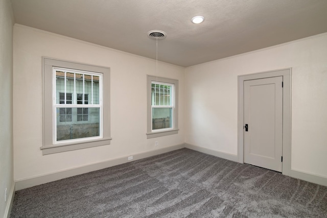 carpeted empty room featuring a textured ceiling