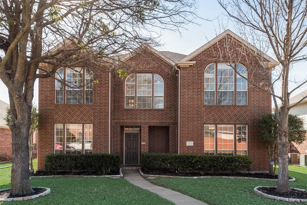 view of front of property featuring a front yard and central AC unit