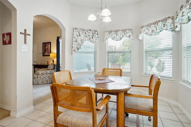 tiled dining space with a chandelier