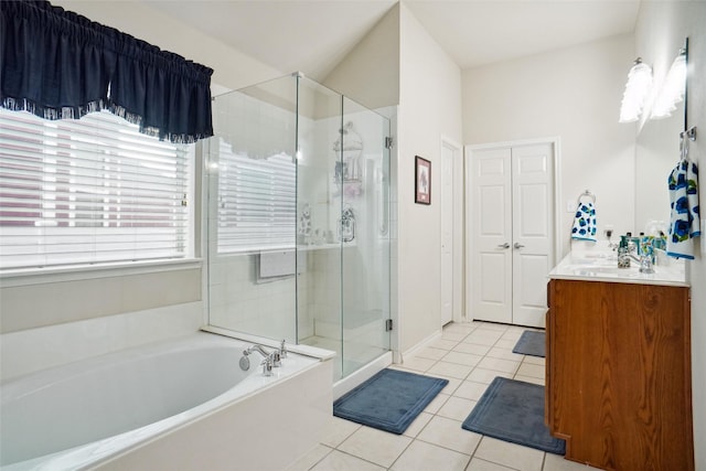 bathroom with tile patterned flooring, vanity, and plus walk in shower