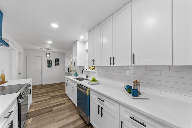 kitchen featuring sink, light wood-type flooring, white cabinets, and appliances with stainless steel finishes