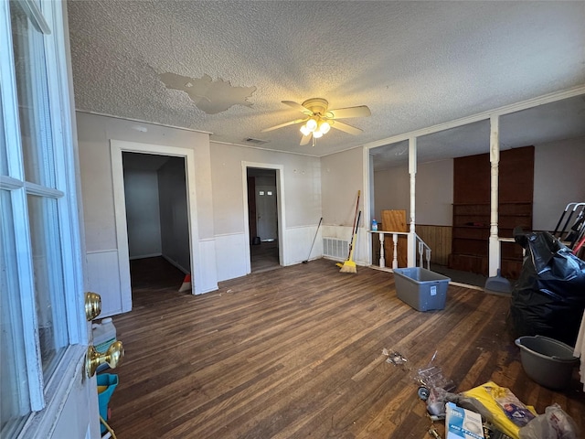 miscellaneous room featuring ceiling fan, dark hardwood / wood-style flooring, and a textured ceiling