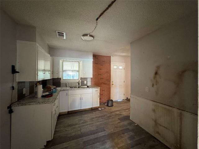 kitchen with white cabinetry, sink, dark wood-type flooring, and a textured ceiling