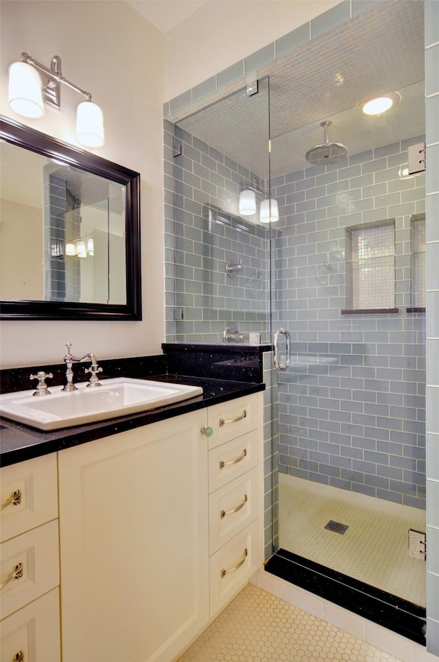 bathroom featuring tile patterned floors, vanity, and a shower with shower door