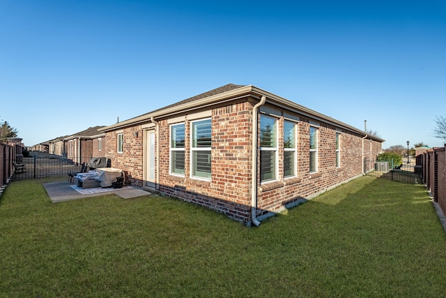 view of property exterior featuring brick siding, a yard, and a fenced backyard