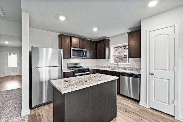 kitchen with a kitchen island, sink, light hardwood / wood-style floors, stainless steel appliances, and a healthy amount of sunlight