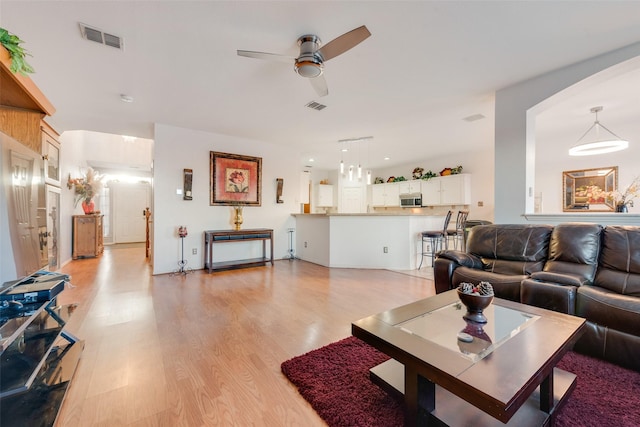 living room with ceiling fan and light hardwood / wood-style floors