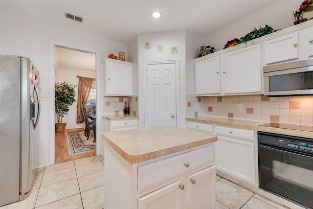 kitchen featuring a kitchen island, light tile patterned floors, white cabinetry, and black appliances