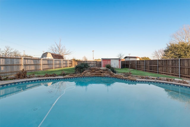 view of pool featuring a yard and a storage shed