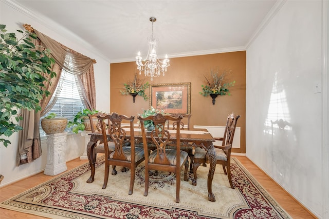 dining area with hardwood / wood-style flooring, a chandelier, and ornamental molding