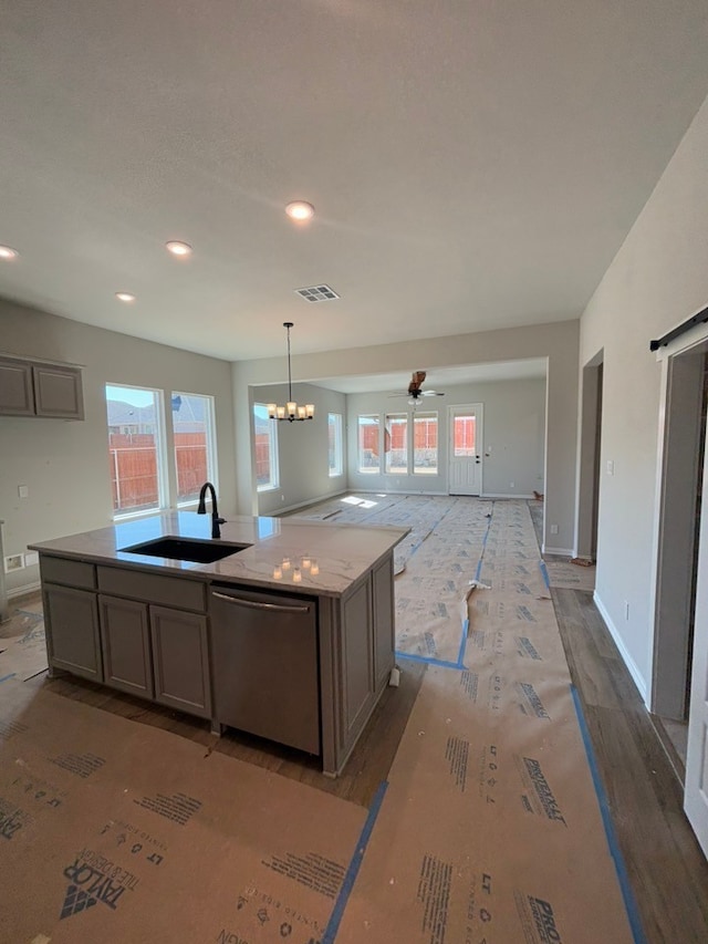 kitchen with visible vents, an island with sink, a sink, open floor plan, and dishwasher