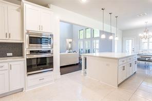 kitchen featuring white cabinetry, a healthy amount of sunlight, a kitchen island, and hanging light fixtures