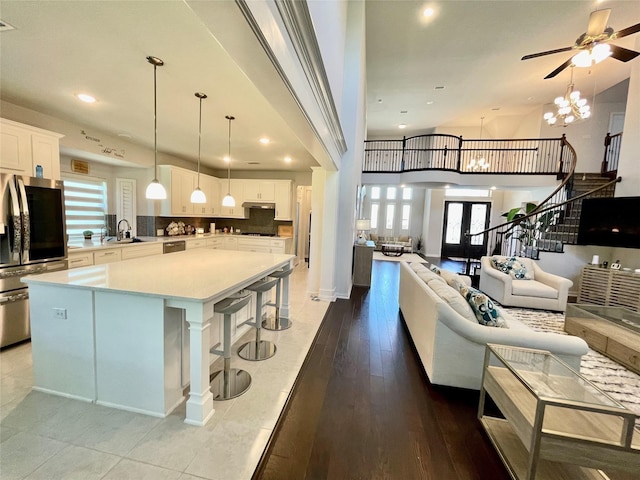 kitchen with sink, decorative light fixtures, appliances with stainless steel finishes, a kitchen island, and white cabinets