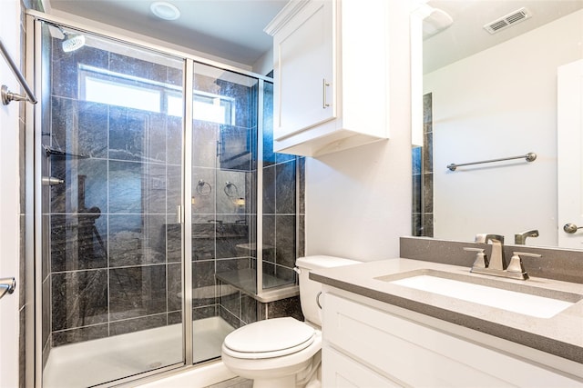 bathroom with vanity, a shower with shower door, and toilet