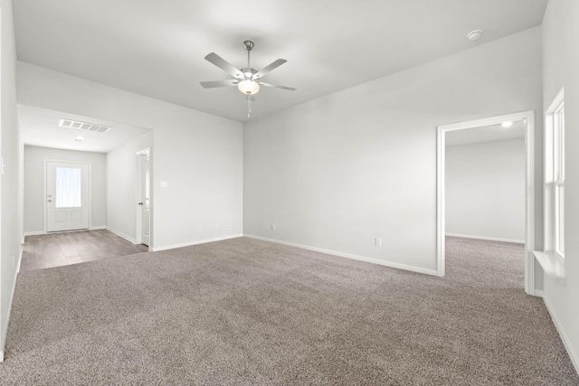 carpeted spare room featuring ceiling fan