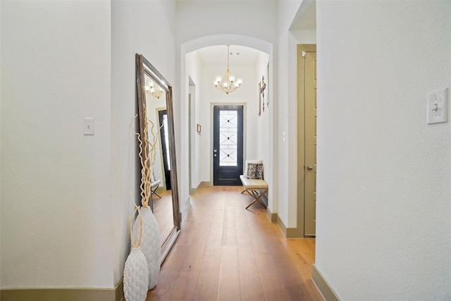 hallway featuring light hardwood / wood-style flooring and a notable chandelier