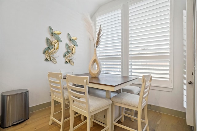 dining space with lofted ceiling and light wood-type flooring