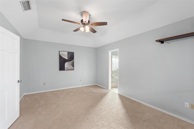 carpeted empty room with ceiling fan and a raised ceiling