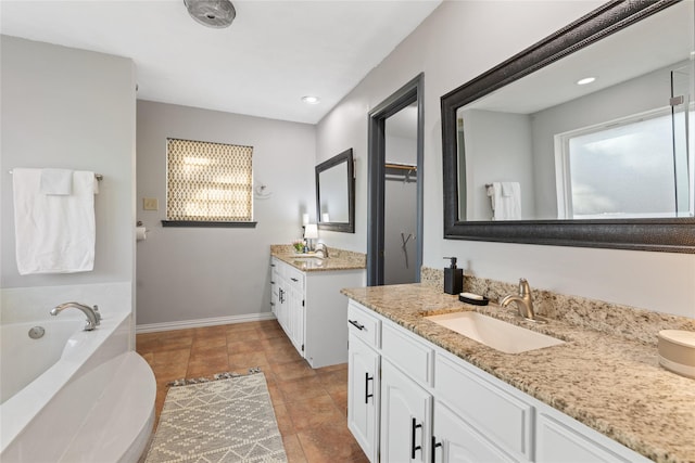 bathroom with vanity, tile patterned flooring, and a bathtub