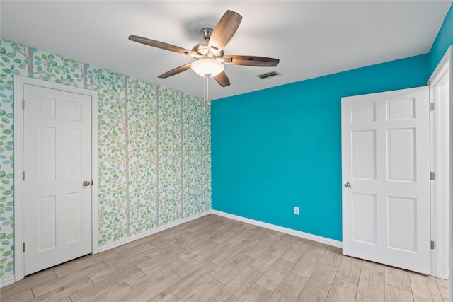 unfurnished bedroom with ceiling fan and light wood-type flooring