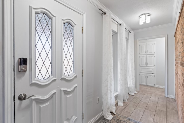 foyer with ornamental molding and a textured ceiling