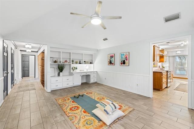 interior space with built in desk, built in features, and ceiling fan