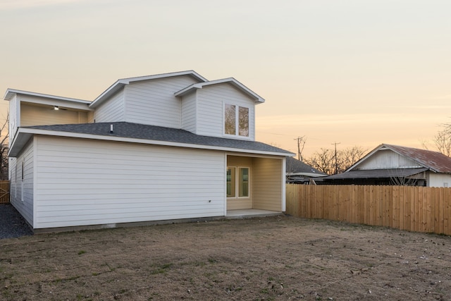 view of back house at dusk