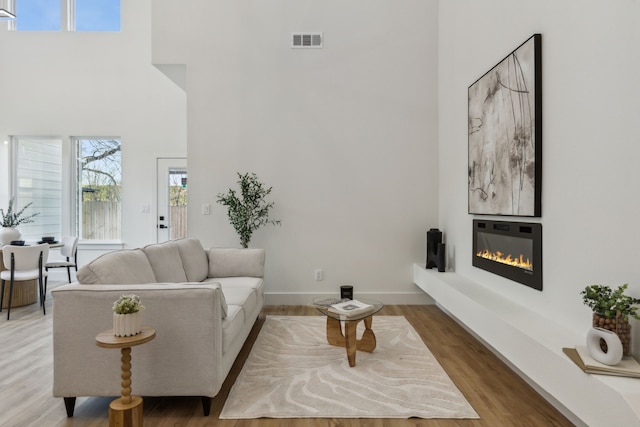 living room featuring hardwood / wood-style floors and a towering ceiling