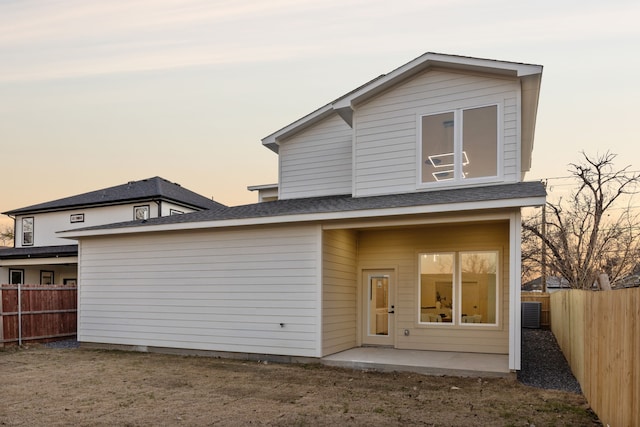 back house at dusk featuring a patio