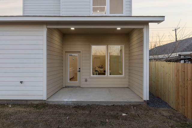 exterior entry at dusk featuring a patio