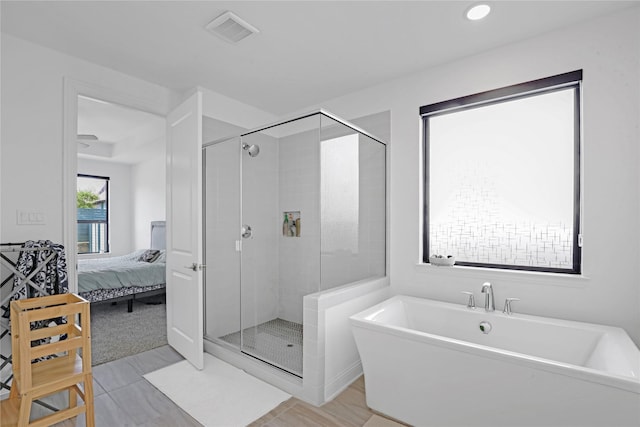 bathroom featuring shower with separate bathtub