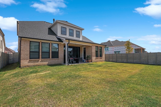 rear view of house with a patio and a yard