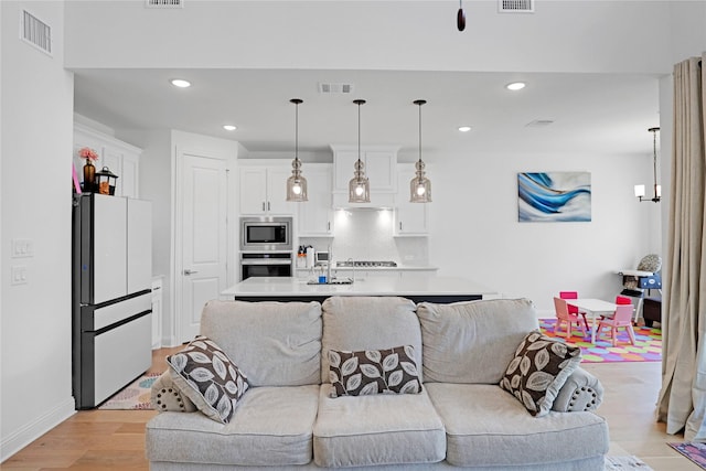 living room with sink and light hardwood / wood-style floors