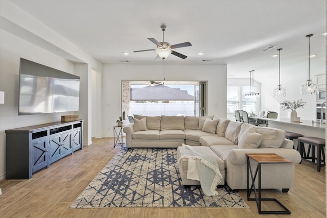 living room with plenty of natural light, ceiling fan, and light hardwood / wood-style flooring