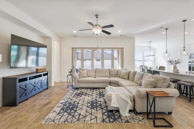 living room featuring ceiling fan and light hardwood / wood-style flooring