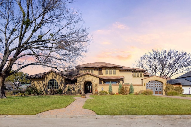 mediterranean / spanish home featuring a yard