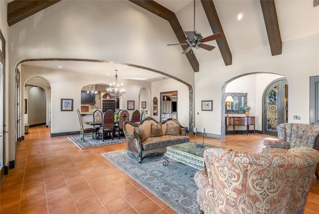 living room featuring light tile patterned floors, beam ceiling, ceiling fan with notable chandelier, and high vaulted ceiling