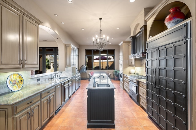 kitchen featuring sink, decorative backsplash, wall chimney range hood, and a kitchen island