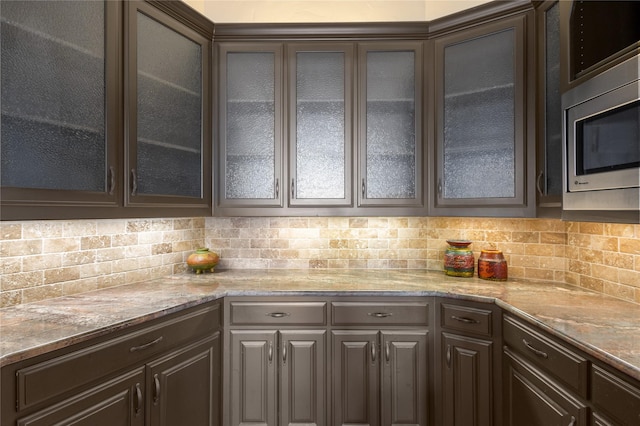 kitchen featuring decorative backsplash and dark brown cabinets