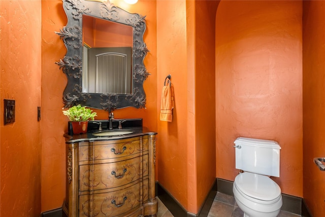 bathroom featuring vanity, tile patterned flooring, and toilet