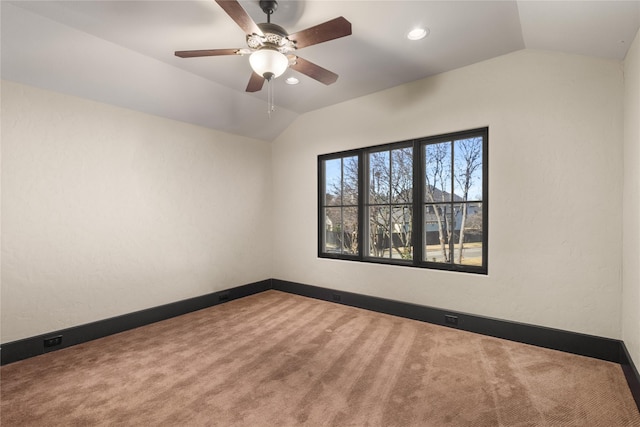 spare room with vaulted ceiling, carpet, and ceiling fan