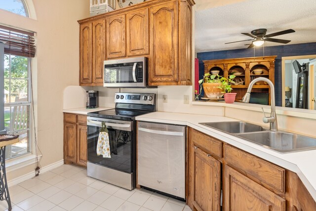 kitchen with lofted ceiling, plenty of natural light, stainless steel fridge, and light tile patterned floors