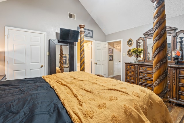 bedroom featuring visible vents, high vaulted ceiling, and wood finished floors