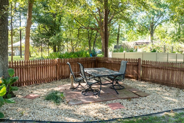 view of yard with a fenced backyard, outdoor dining area, and a patio