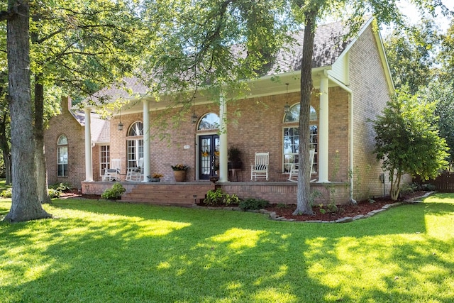 view of front of property with brick siding, a porch, and a front yard