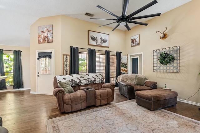 living area with visible vents, high vaulted ceiling, a ceiling fan, wood finished floors, and baseboards