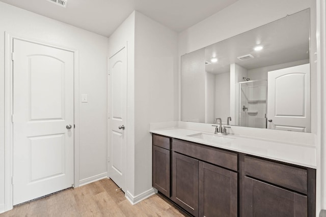 bathroom featuring vanity, wood-type flooring, and walk in shower