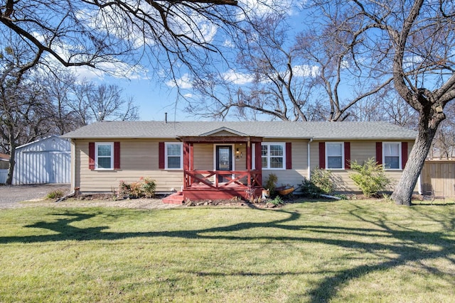 single story home featuring a garage, an outdoor structure, and a front yard