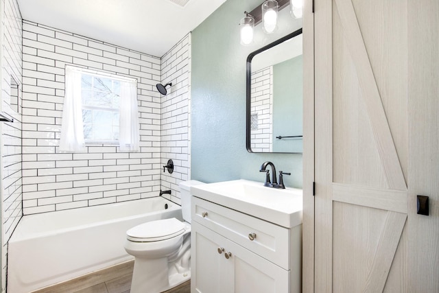 full bathroom featuring tiled shower / bath, hardwood / wood-style floors, vanity, and toilet